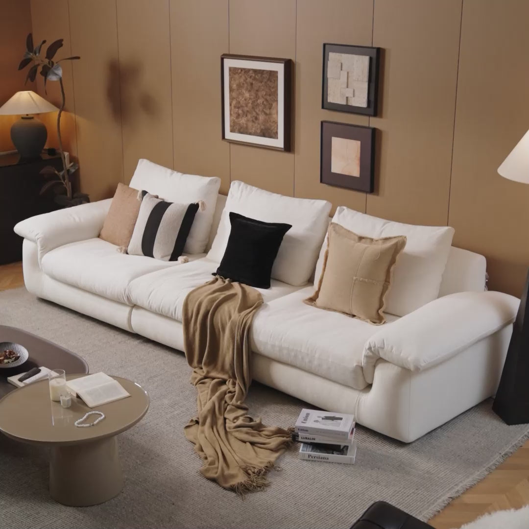 MIRELANO cloud sofa in a modern home setting with a woman sitting, reading, and relaxing comfortably